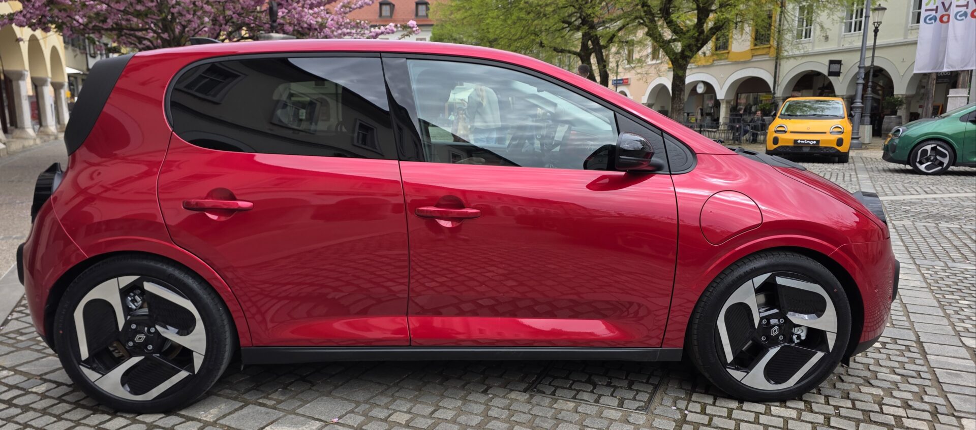 Crveni Twingo E-Tech electric fotografiran bočno, u pozadini su žuti i zeleni tvingo